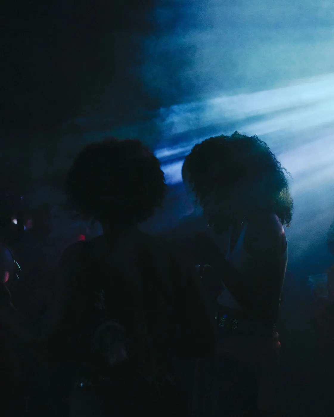 Two figures close together in silhouette, an intimate candid moment on the floor