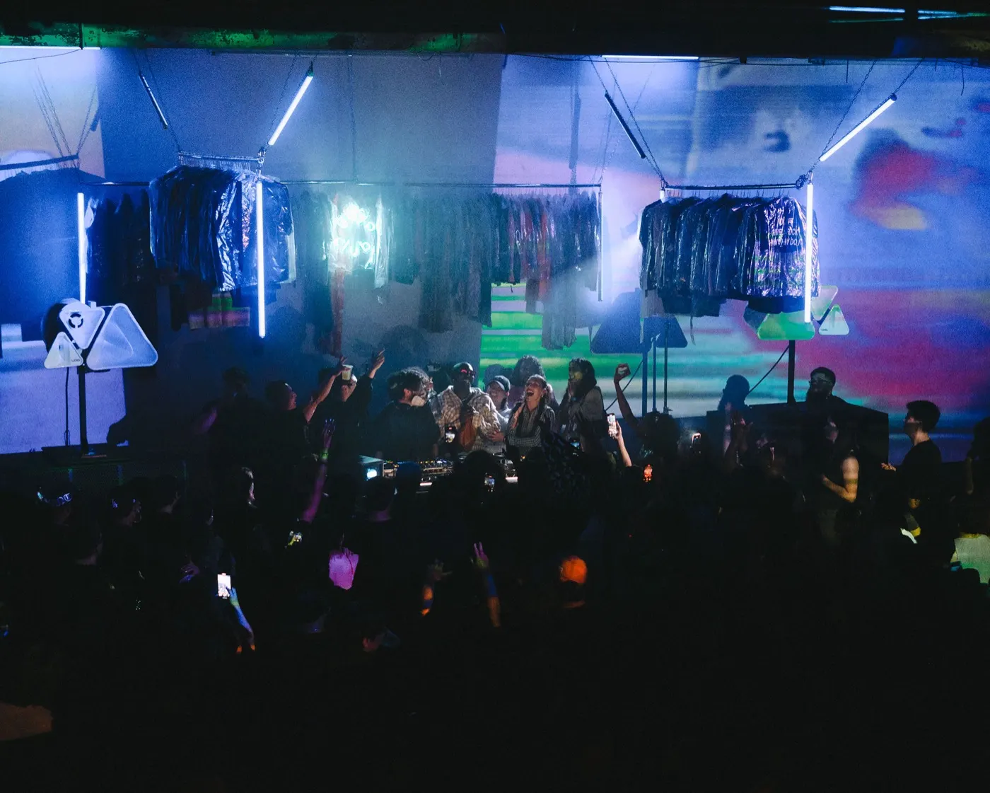 Wide shot of the crowd dancing under colorful stage lighting