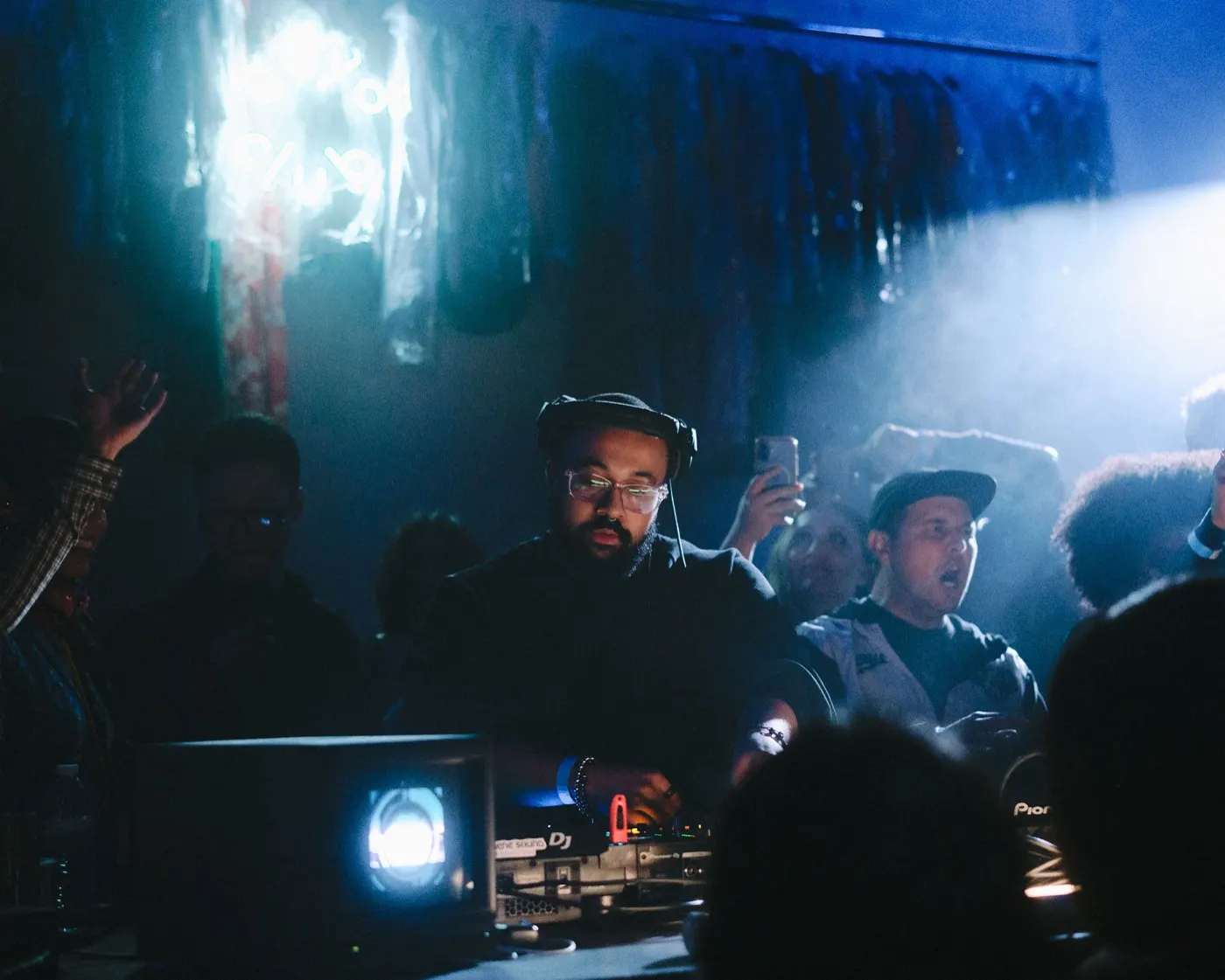 Two DJs at the booth together, one gesturing toward the mic