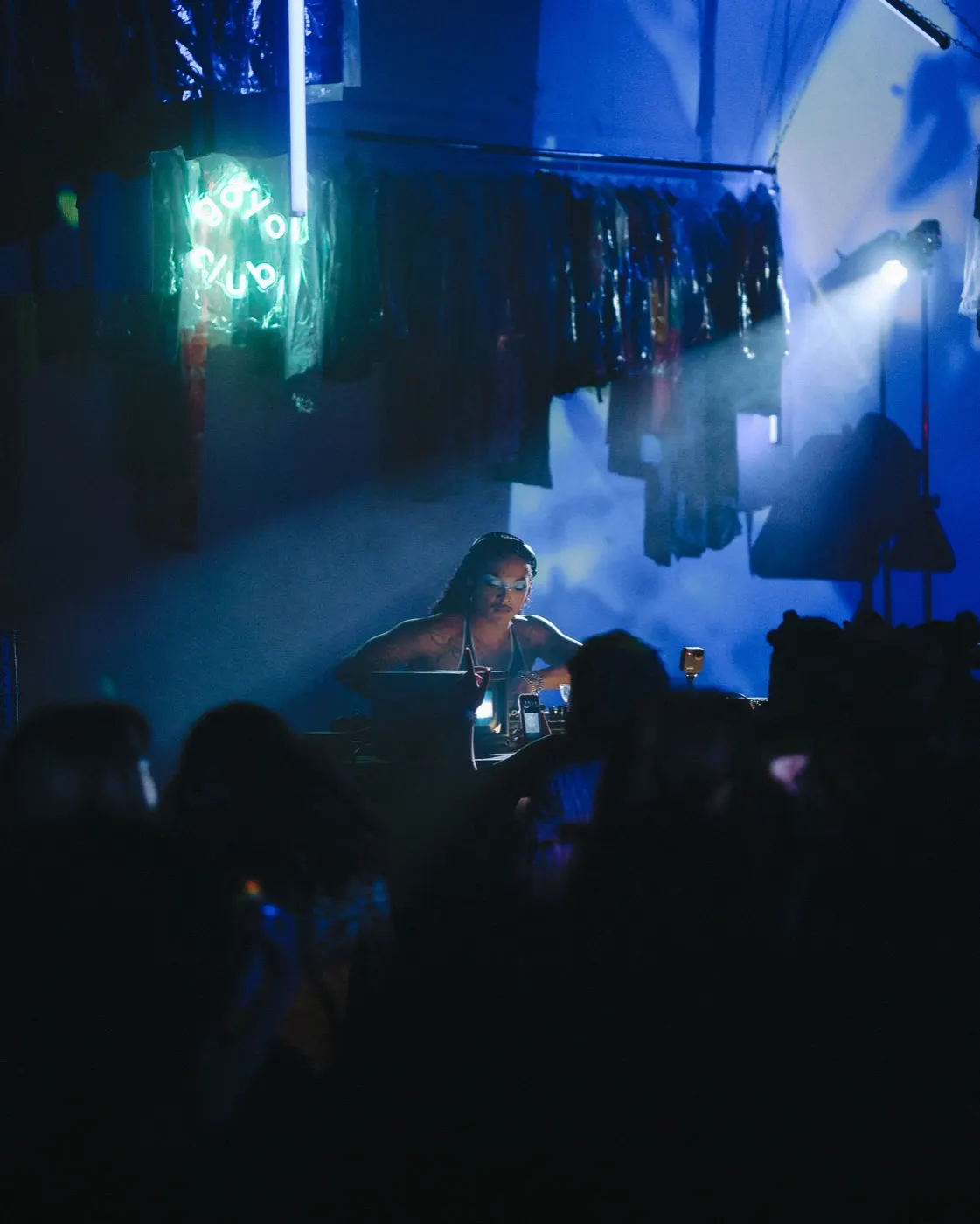 Crowd silhouettes close to the booth in a blue-green colorful wash