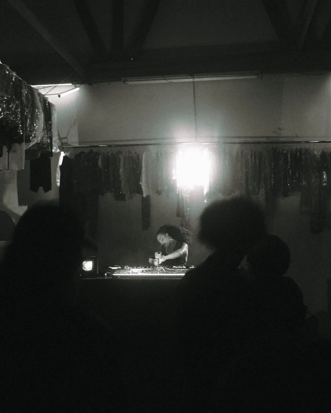 Black-and-white candid of two silhouetted figures near a light source