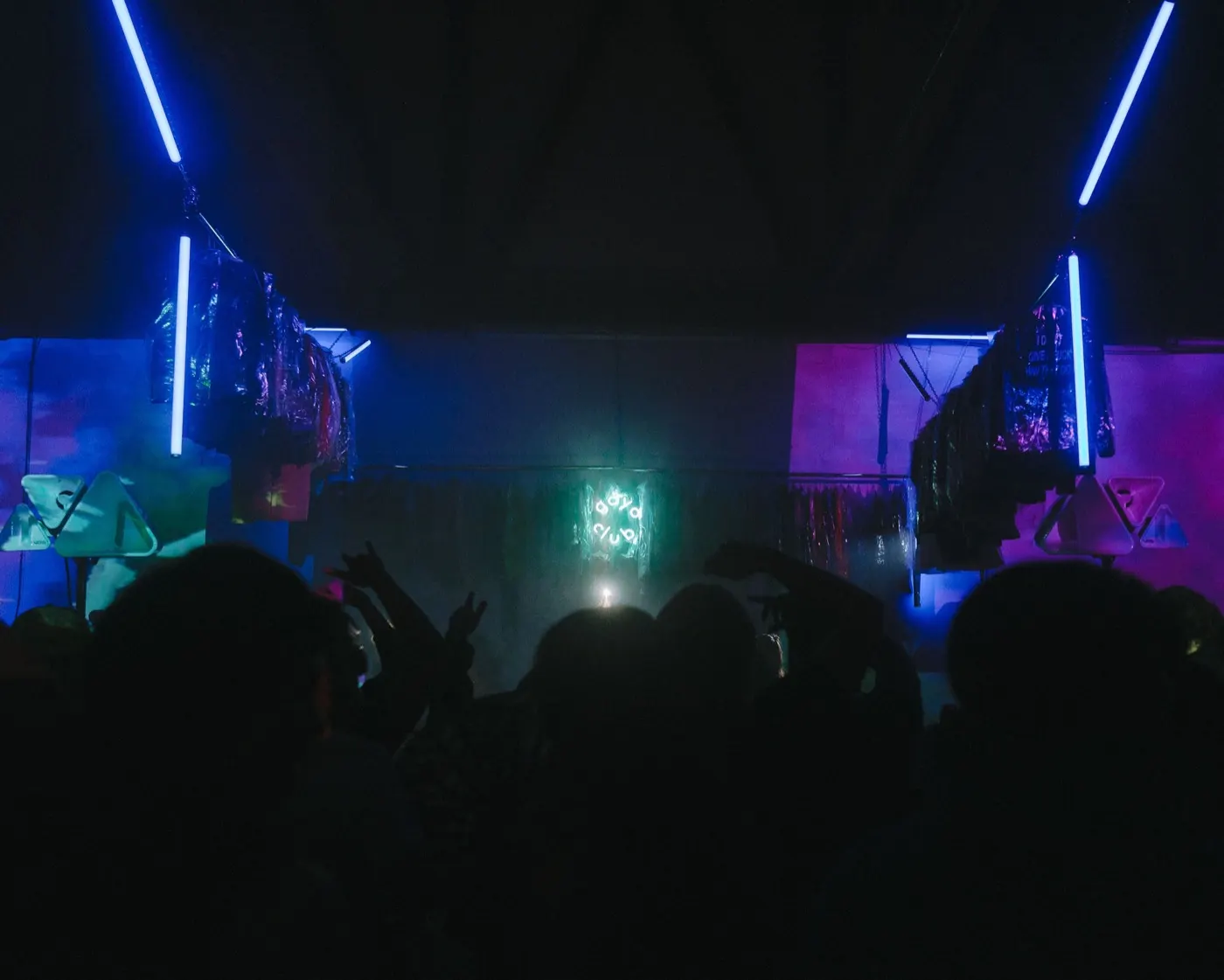 Wide colorful stage shot with the dense crowd under teal and pink lighting