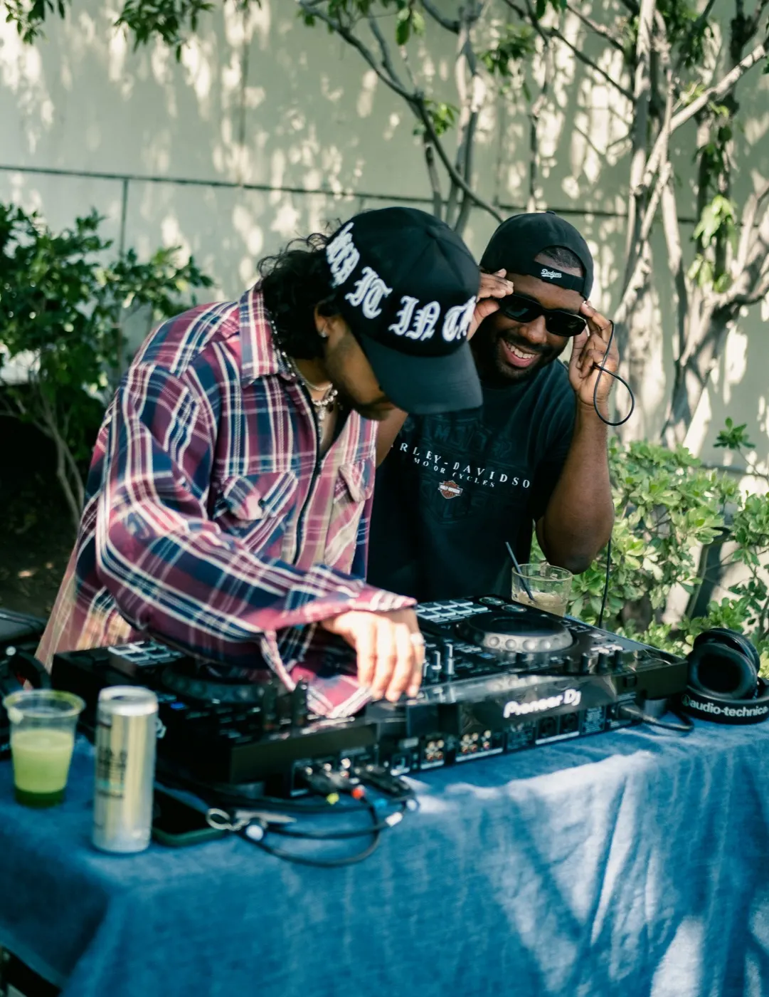 Two DJs laughing together behind the turntables
