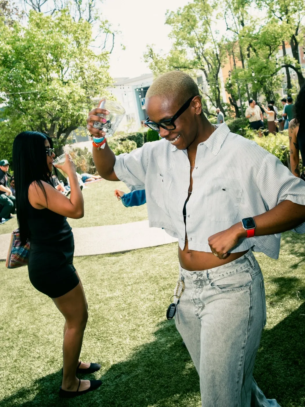 A guest dancing energetically on the lawn with a drink in hand