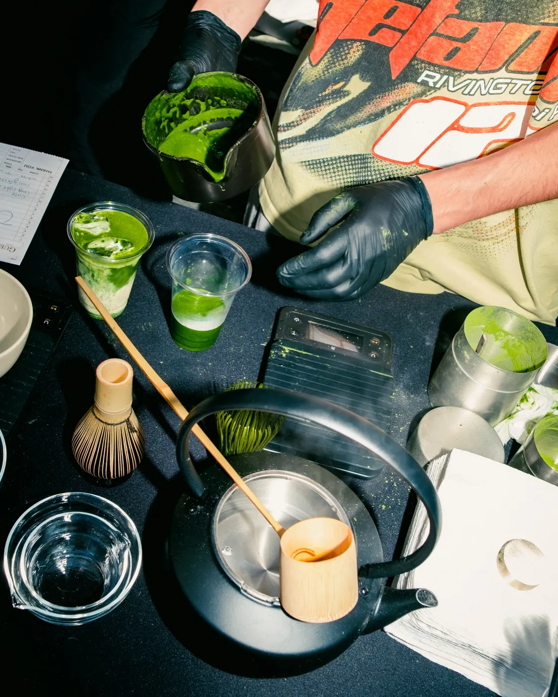 Close-up of matcha being whisked and poured into cups