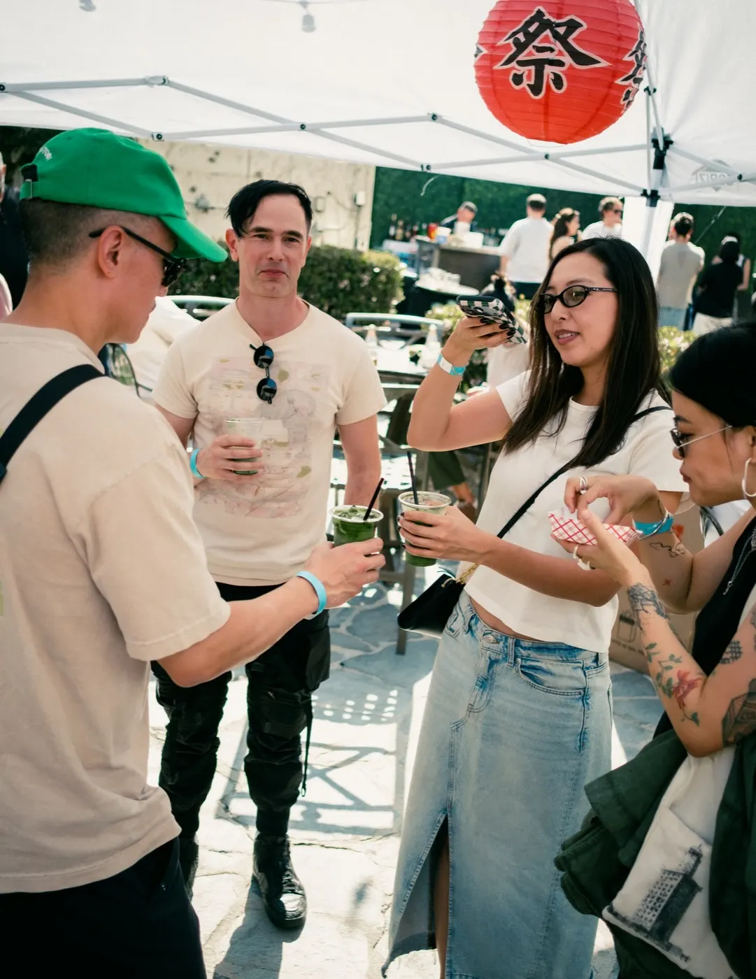 Guests smiling at the matcha stand beneath string lights