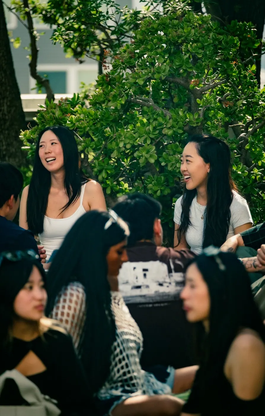 A group of friends laughing together on the lawn
