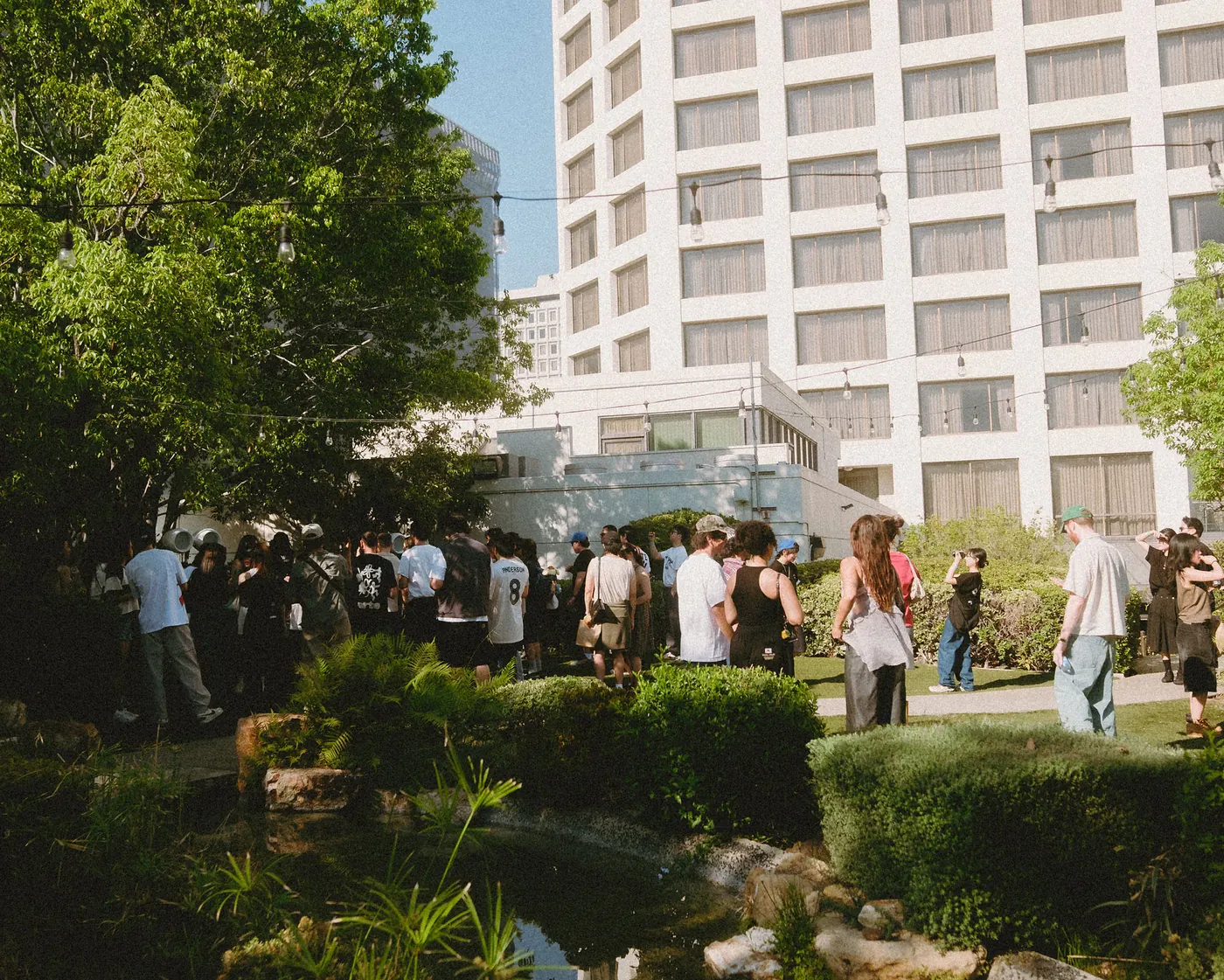 Crowd spread across the garden lawn with the DoubleTree tower behind