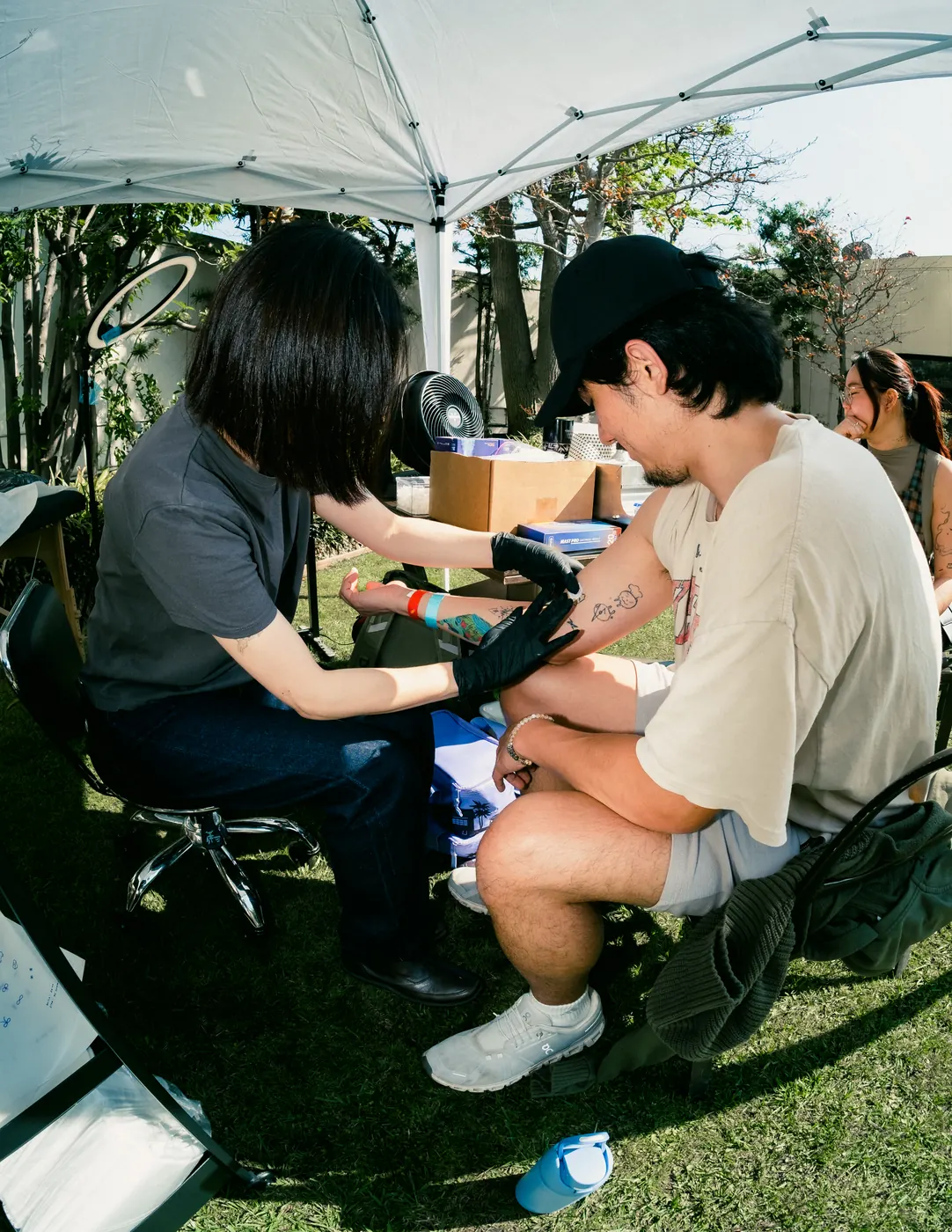 Walk-in tattoo artist at work under the canopy