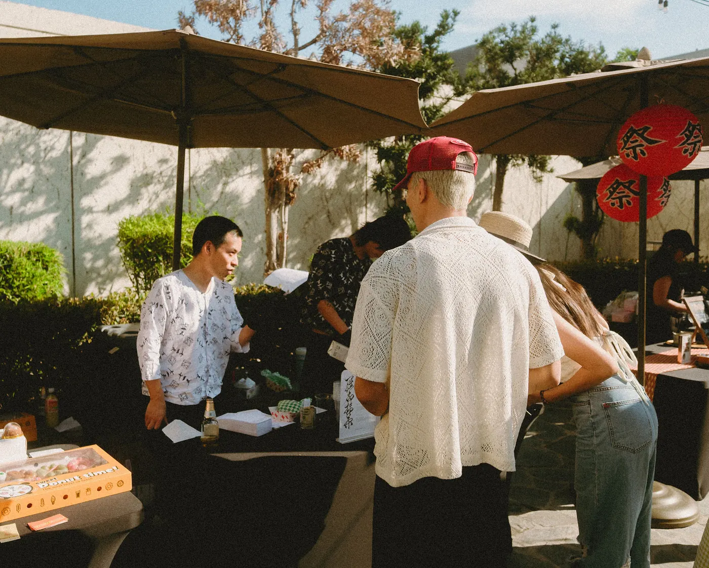 Vendor booths under parasols and paper lanterns