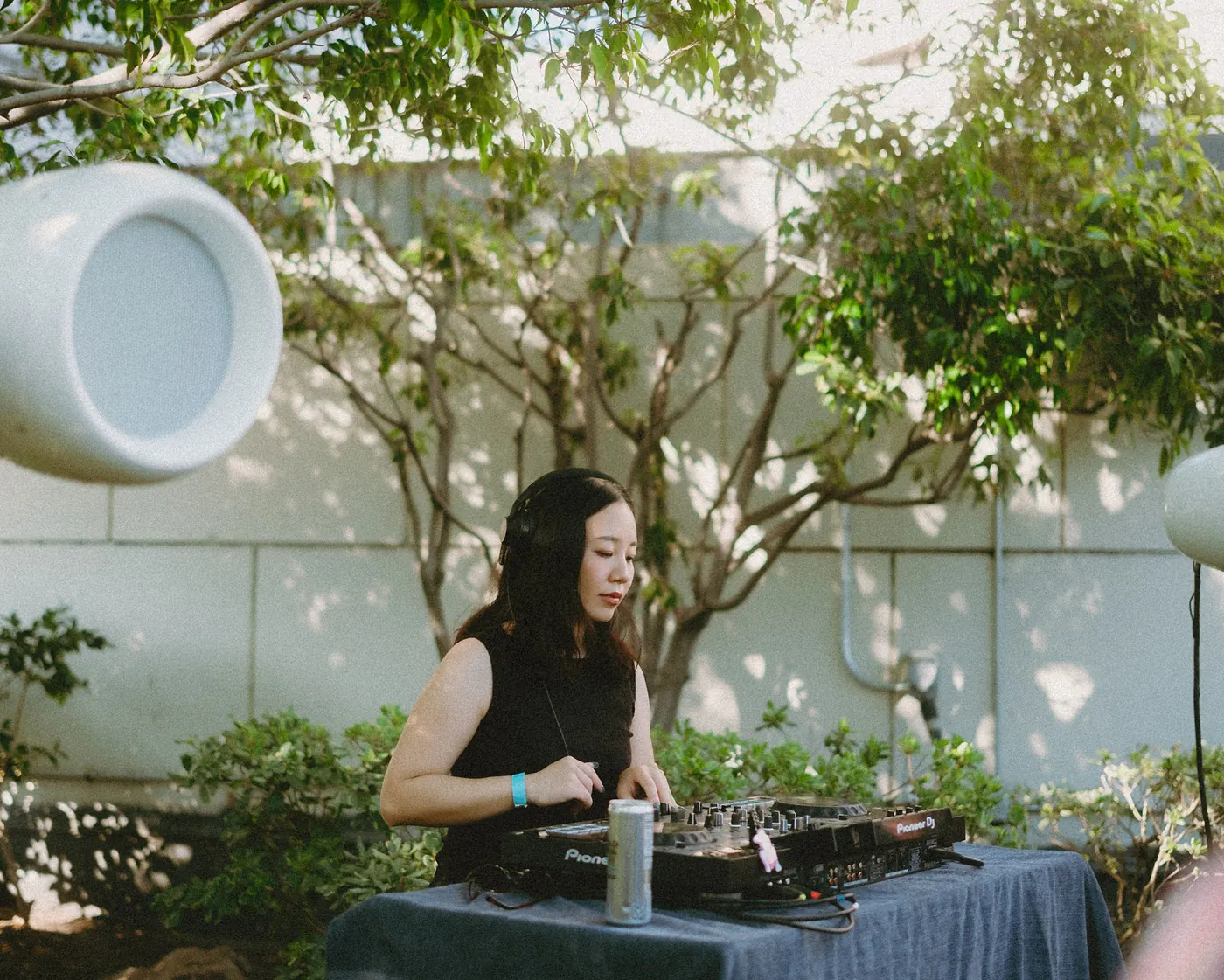 DJ playing on the CDJs under the garden trees