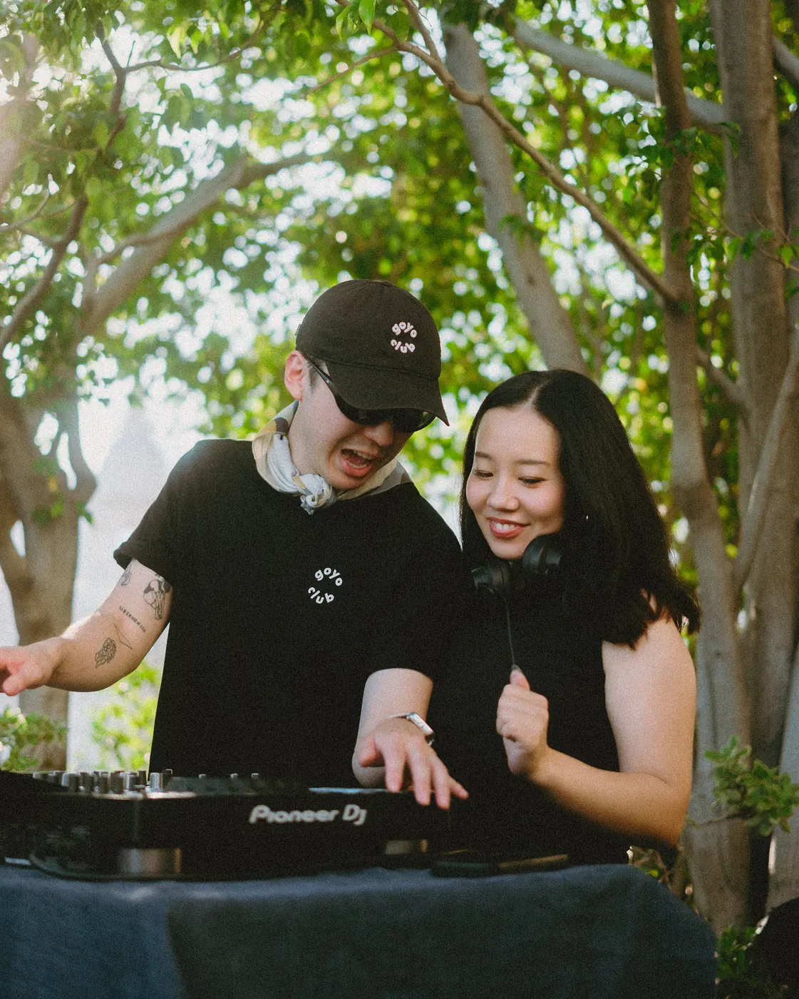Two DJs laughing together during a back-to-back set