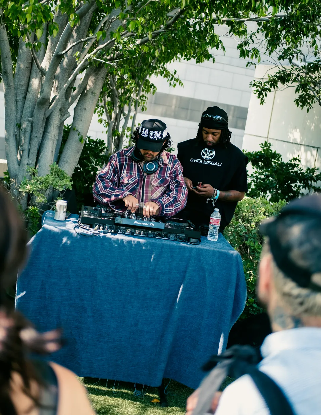 DJ at the blue-draped booth mid-set