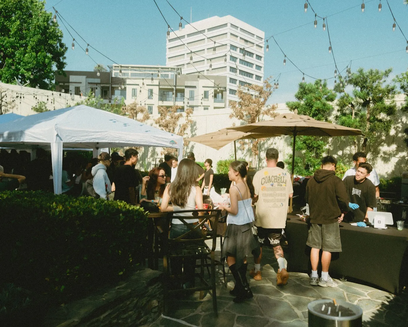 Garden patio with white vendor tents and string lights as guests mingle