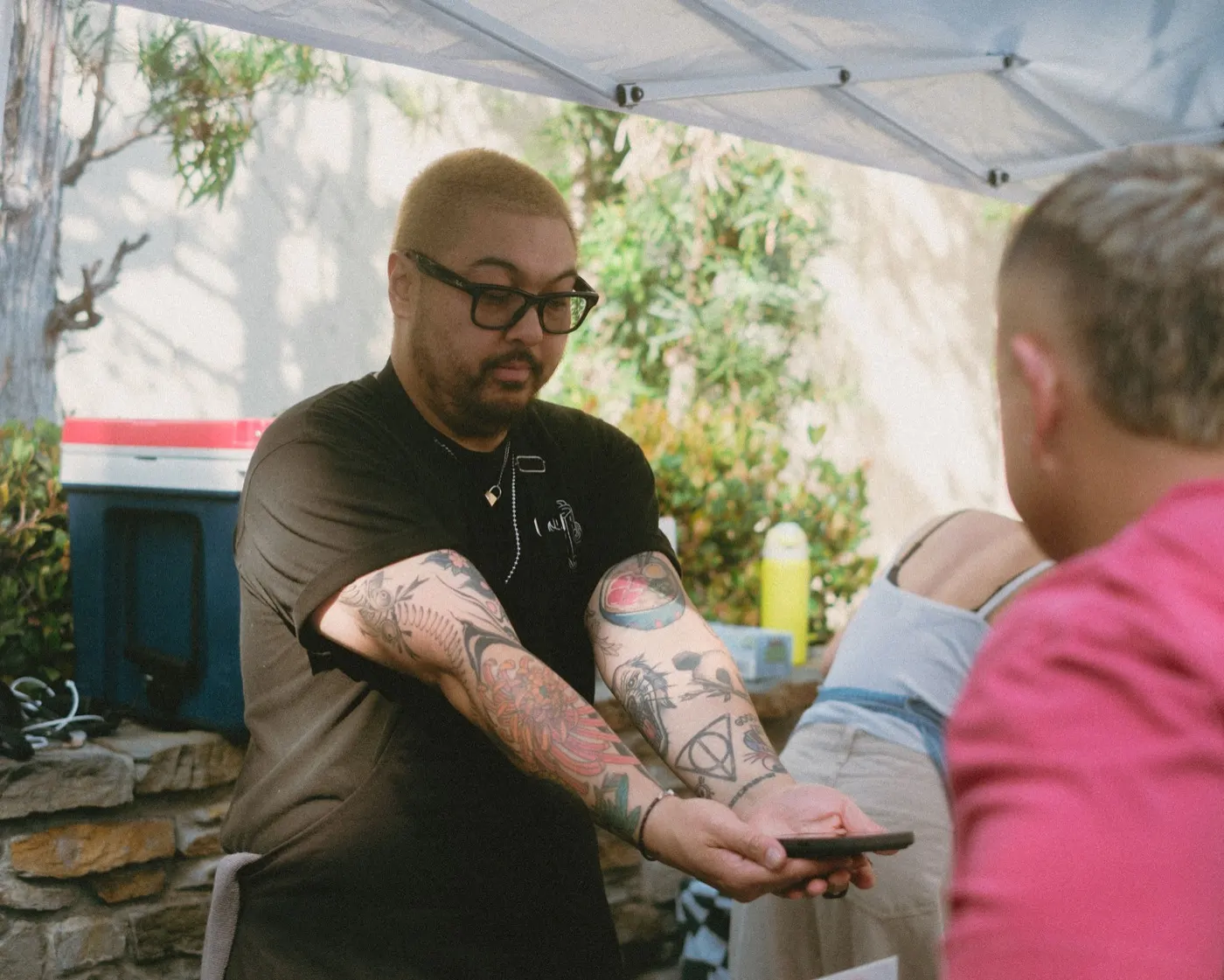 Close-up of a tattooed arm being shown off near the walk-in tattoo booth