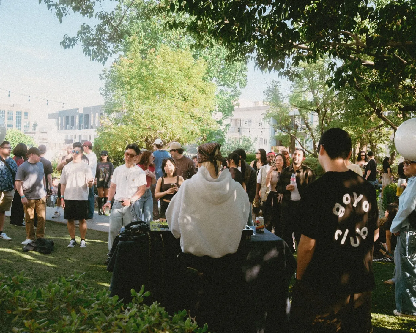 Crowd gathered around the DJ booth, one attendee wearing a goyo club t-shirt