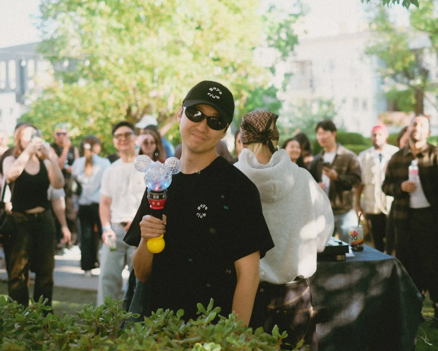 Crowd dancing near the DJ booth with a goyo club branded t-shirt in focus