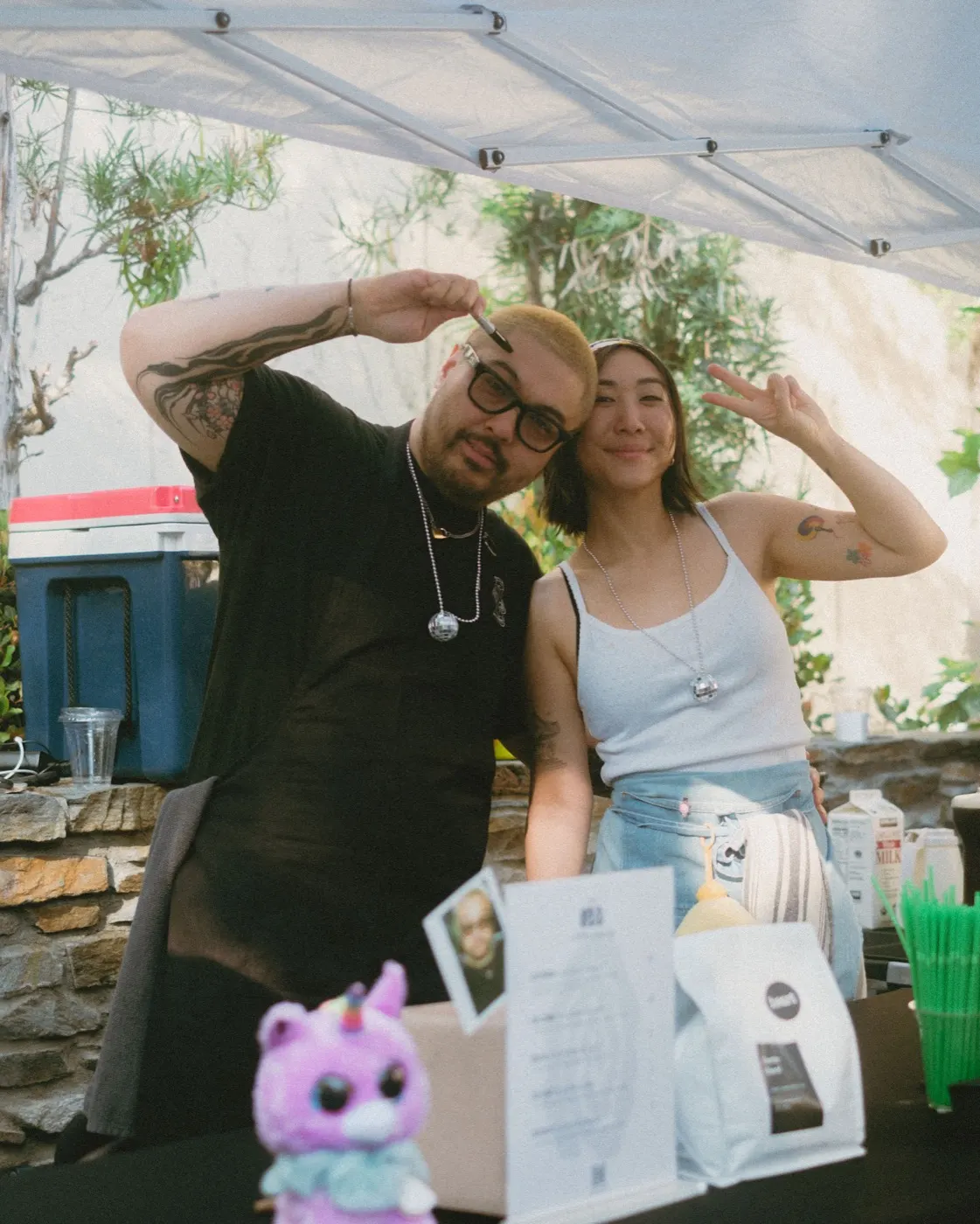 Two vendor staff smiling and posing together under their tent