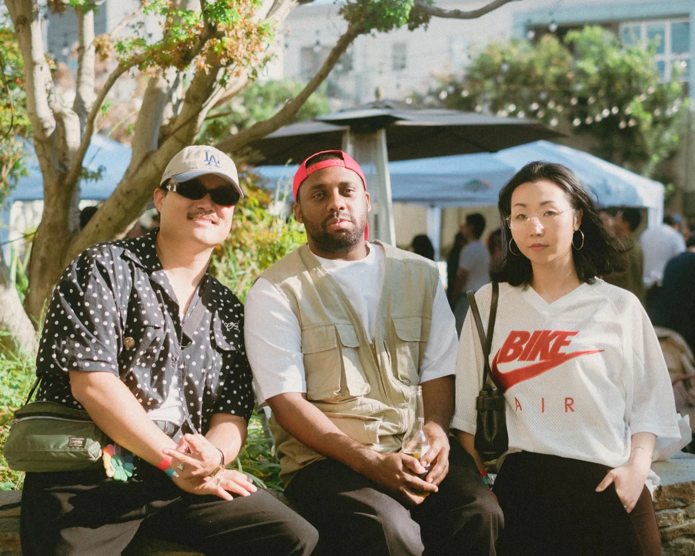 Three friends posing together for a portrait in the garden