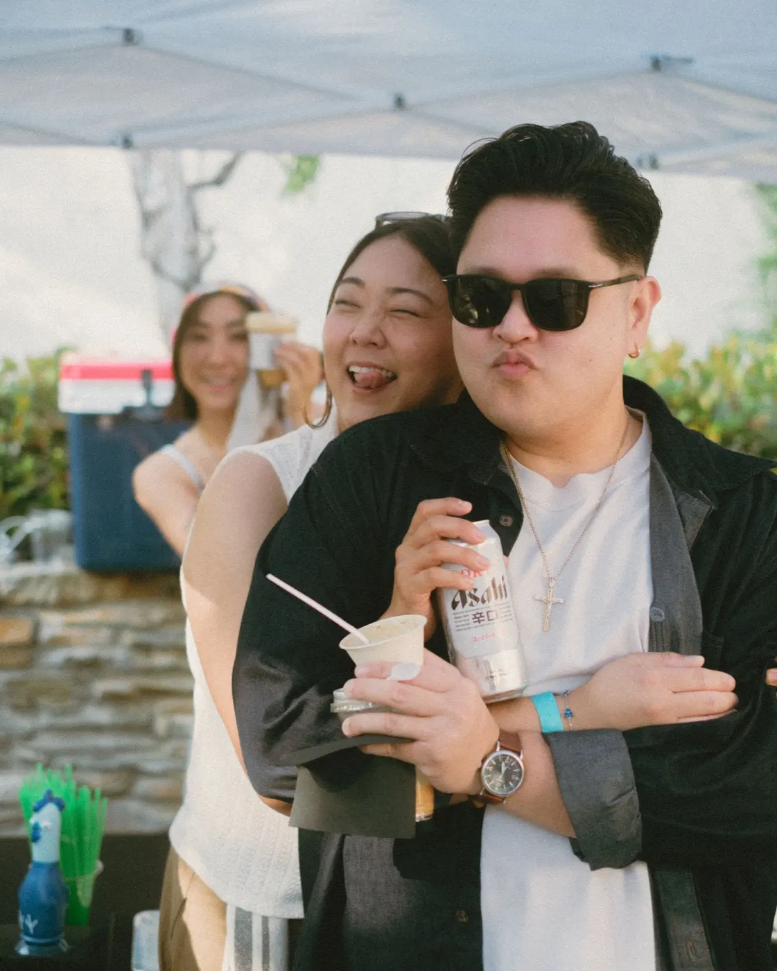 Two friends laughing and posing together at the drinks table