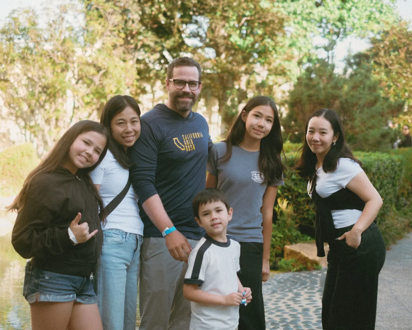 Family group posing together next to the garden pond