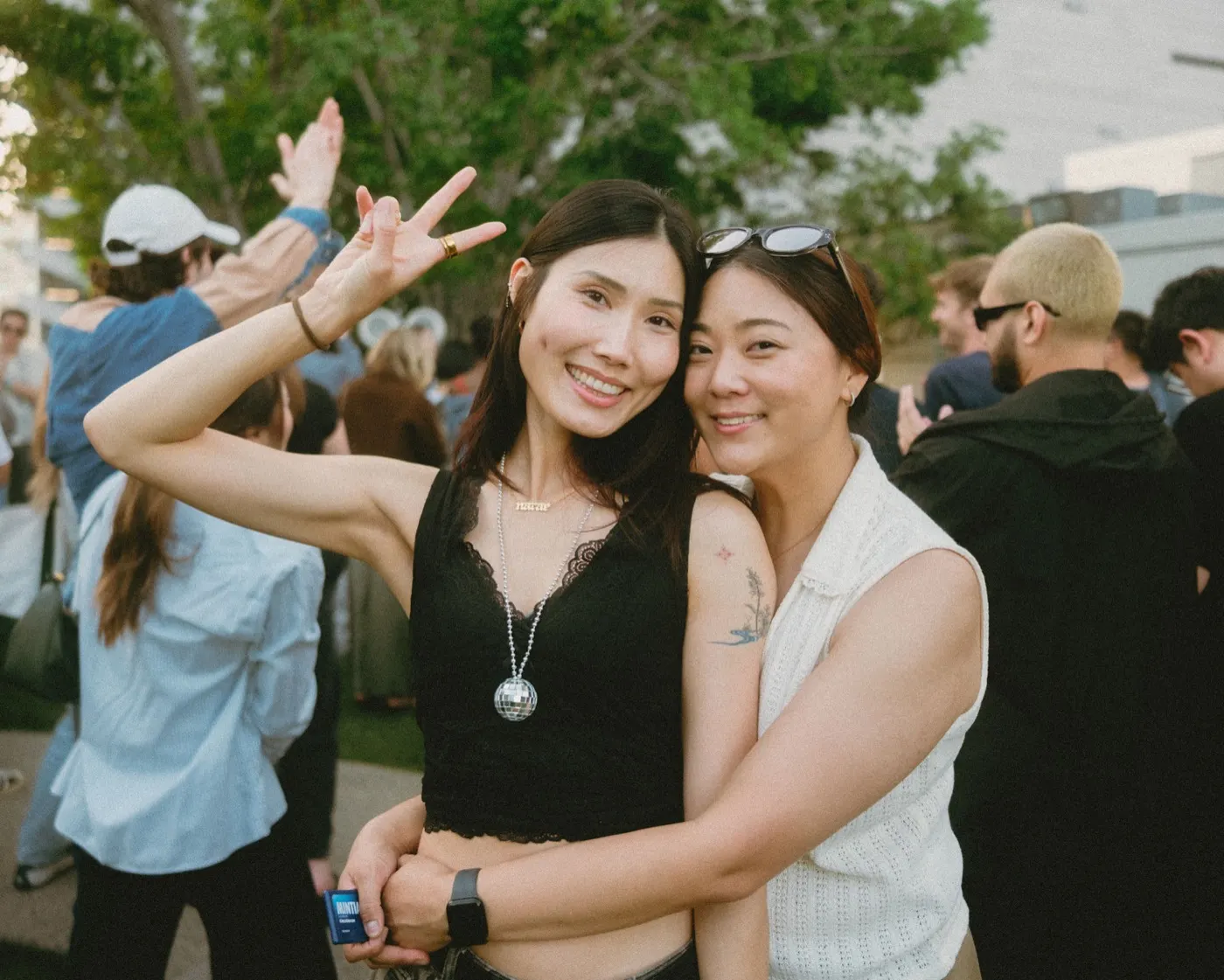 Two friends smiling and posing together at the party